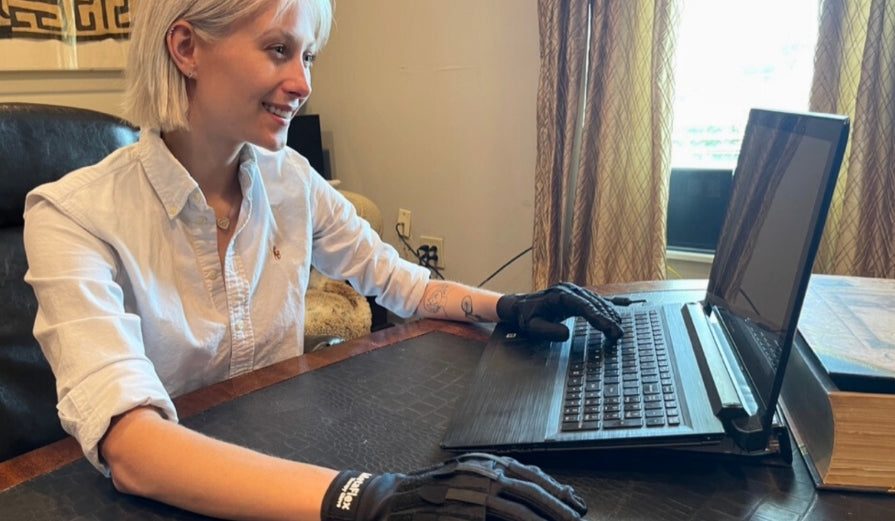 Founder and CEO at ATS Innovations Inc., Téa Phillips, works on a computer while wearing her invention - the MetaFlex grip strengthening compression gloves