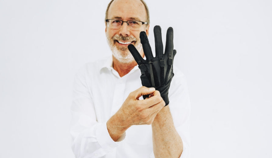 Handsome senior man gives a big smile while personalizing the adjustable resistance bands on his MetaFlex gloves