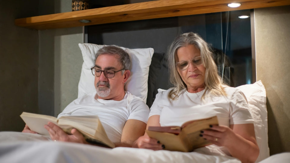 middle aged couple in bed reading together